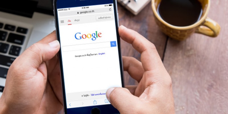 A mobile phone with a Google search engine page open on it