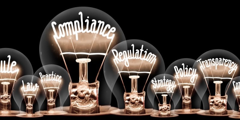 Several lightbulbs highlighting the following words inside them: rule, law, practice, compliance, regulation, strategy, policy, transparency.