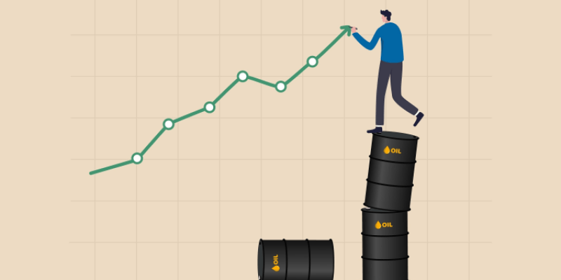 Man balancing on stacked barrels of oil as he draws an ascending graph