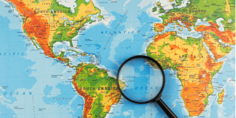 Magnifying glass on top of world map