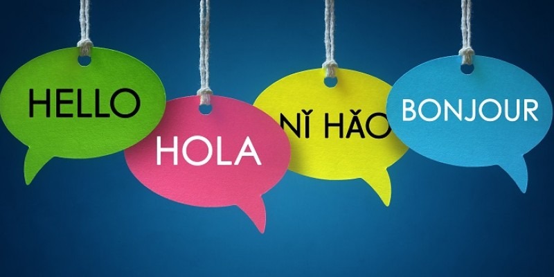 Four cardboard speechbubbles with "hello" written ins 4 different languages.