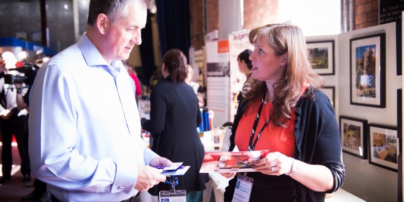 A man and a woman networking at a trade event